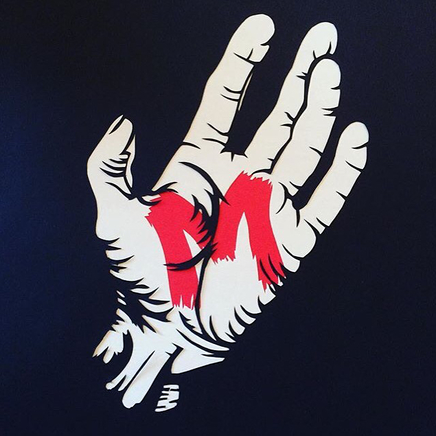 A papercut of the a hand with the letter M upon the palm, from the film M.