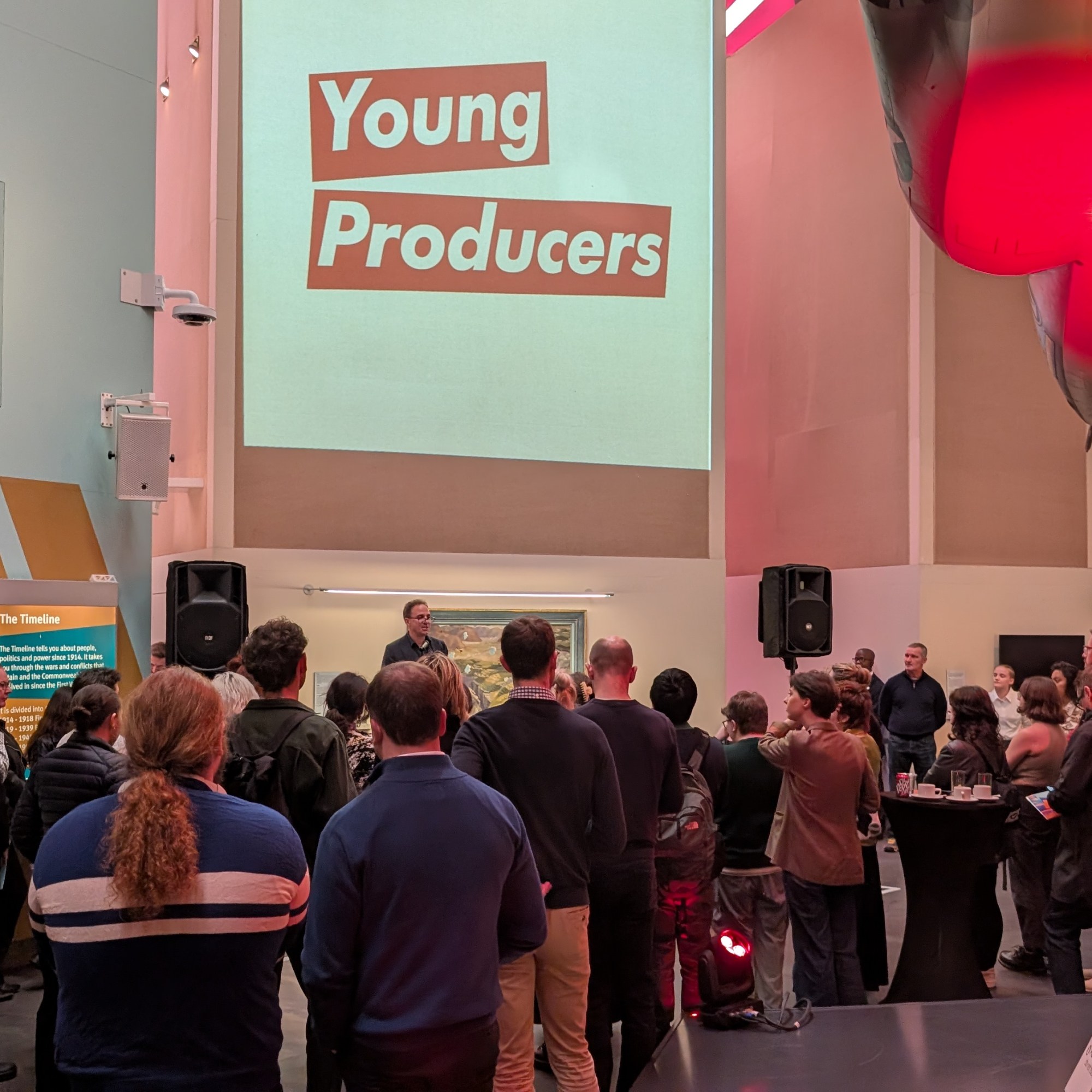The audience gathers for speeches at the Young Producers Exhibition at Imperial War Museum North